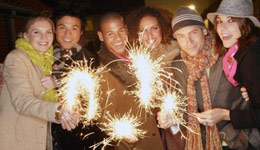 Gruppen junger Leute mit Wunderkerzen zu Silvester