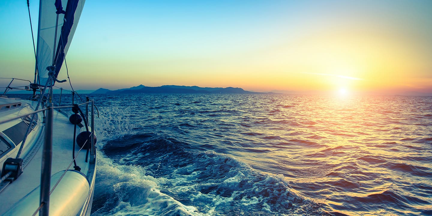 Segelboot auf dem Meer bei Sonnenuntergang