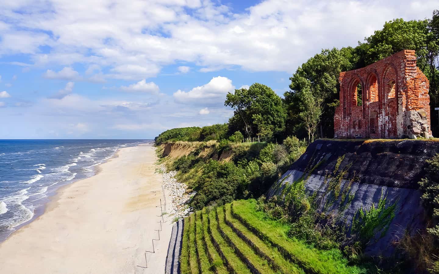 Polnische Ostsee am Strand mit den Ruinen der Kirche in Trzesacz im Sommer
