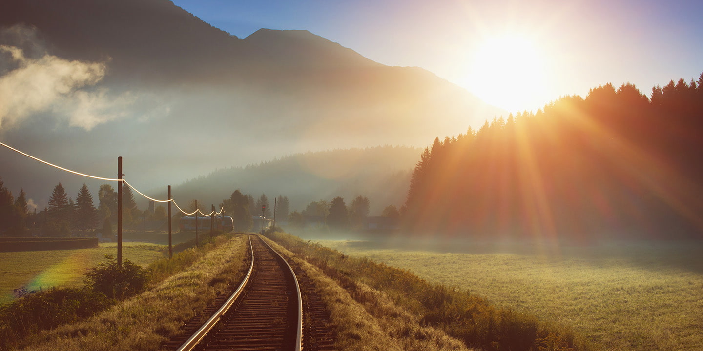 Bahnstrecke in den Alpen bei Sonnenaufgang