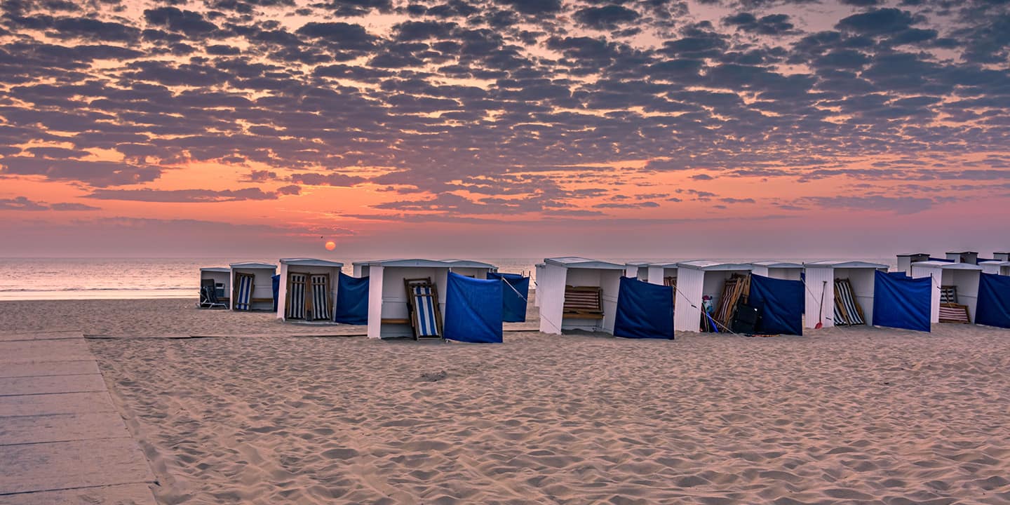Sonnenuntergang mit Strandhütten am niederländischen Strand Katwijk